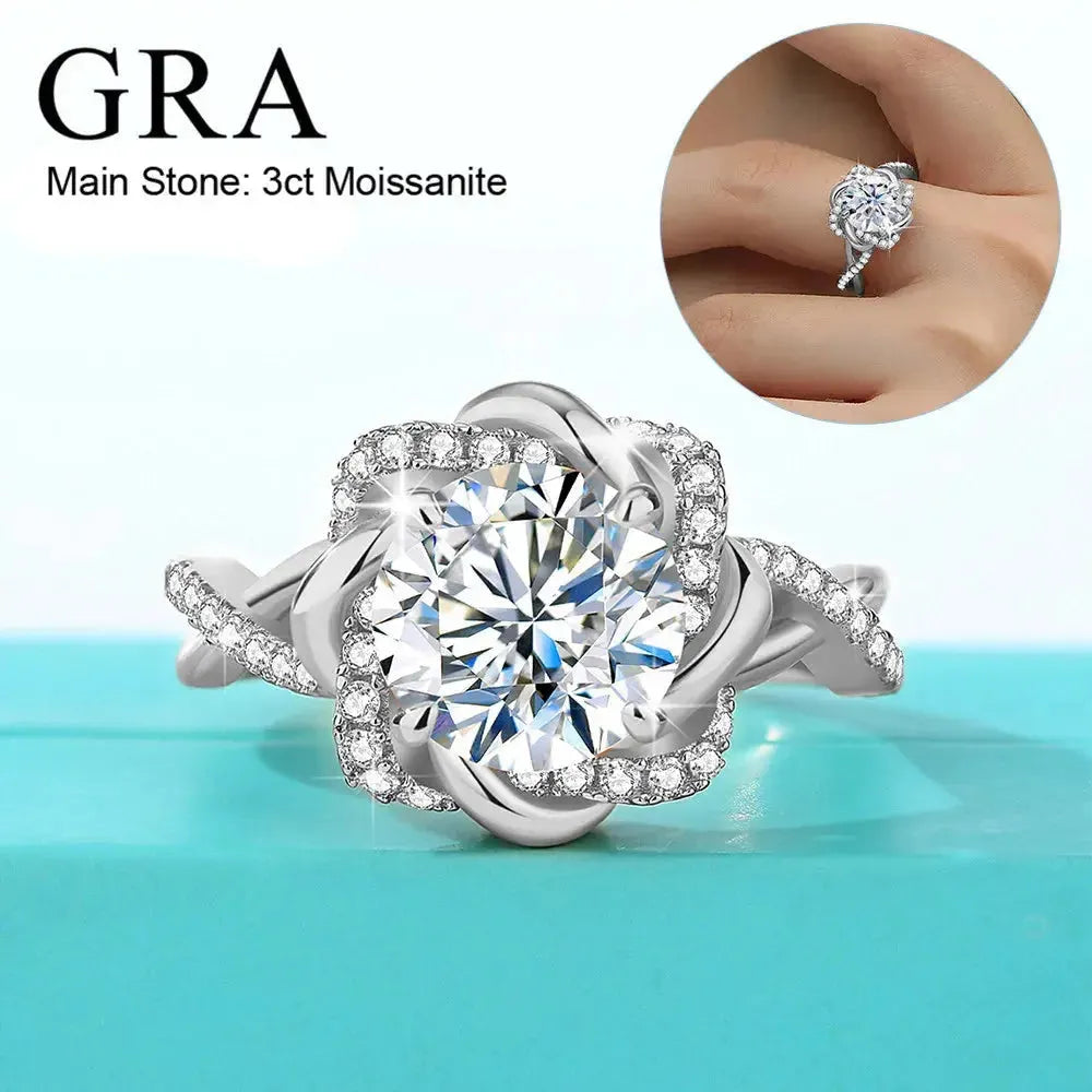 A silver ring featuring a 3-carat moissanite as the main stone, surrounded by smaller stones in a floral design. The ring is displayed on a turquoise surface, with an inset image showing the ring on a person's finger. The text "GRA Main Stone: 3ct Moissanite" is visible.