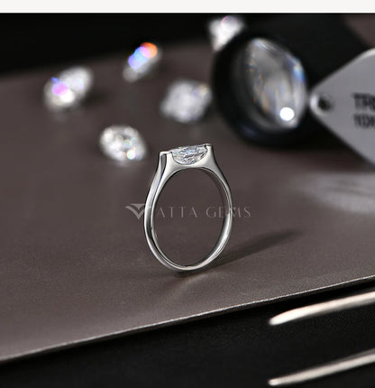Silver ring with a diamond on a dark surface, branded 'Atta Gems'.