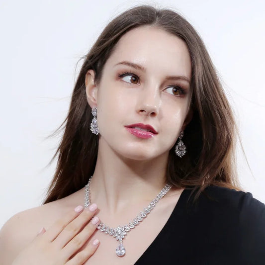 Woman wearing a diamond necklace and earrings on a white background