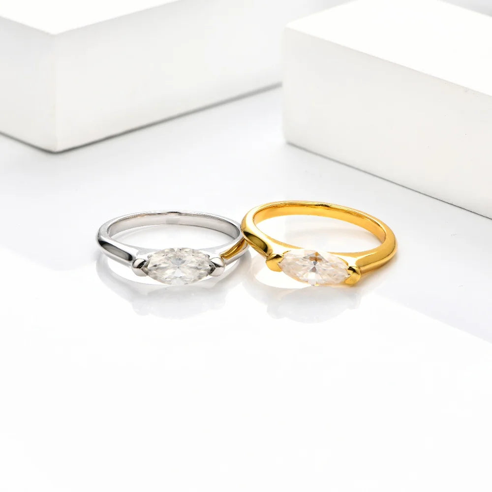 Two rings, one gold and one silver, on a white surface.