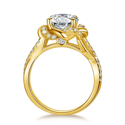 A gold engagement ring with a large central diamond. The band features intricate detailing with smaller diamonds encrusted along the sides and a unique twisted design around the main stone.