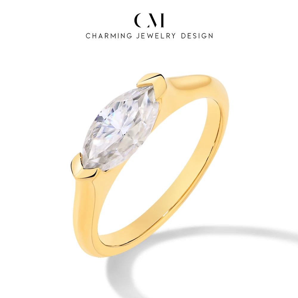 Gold ring with a clear gemstone on a white background, featuring 'Charming Jewelry Design' logo.