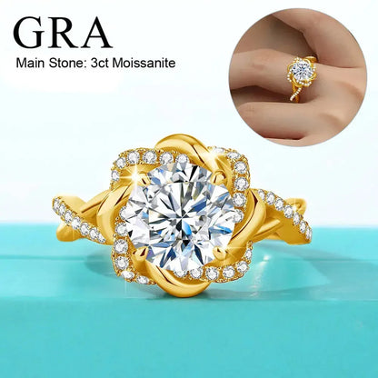A gold ring featuring a large 3-carat moissanite stone in the center, surrounded by smaller stones. The ring has an intricate design with additional stones on the band. A small inset image shows the ring being worn on a finger. The text reads "GRA Main Stone: 3ct Moissanite."